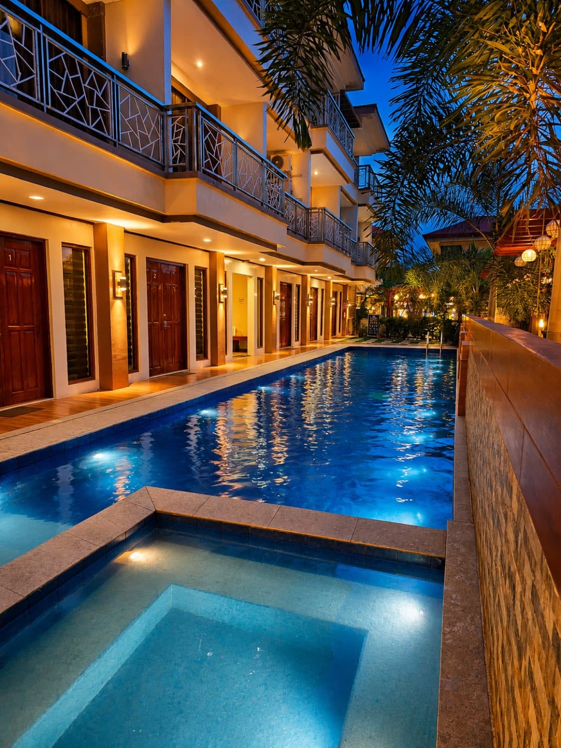 The pool at Cherish Resort glowing at dusk beside the guest rooms